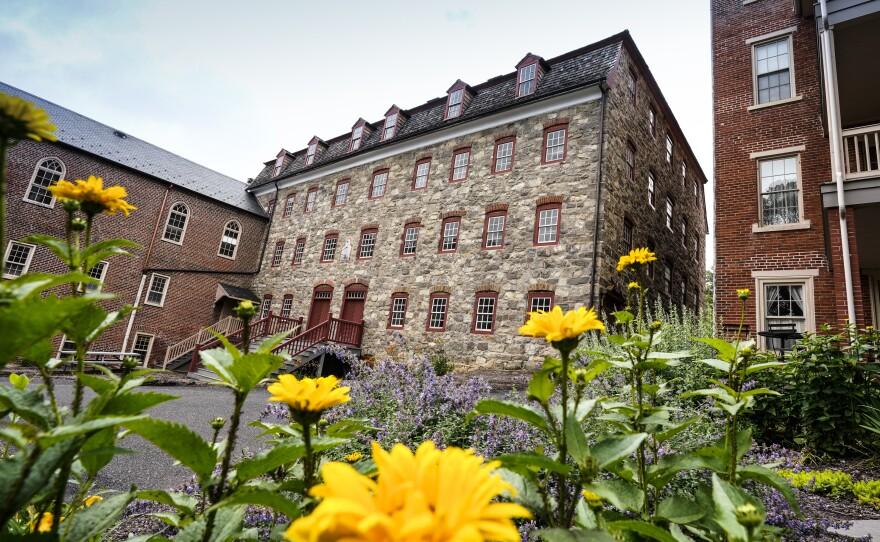 View of the south facade of the Brethren House. Yellow flowers in the foreground.